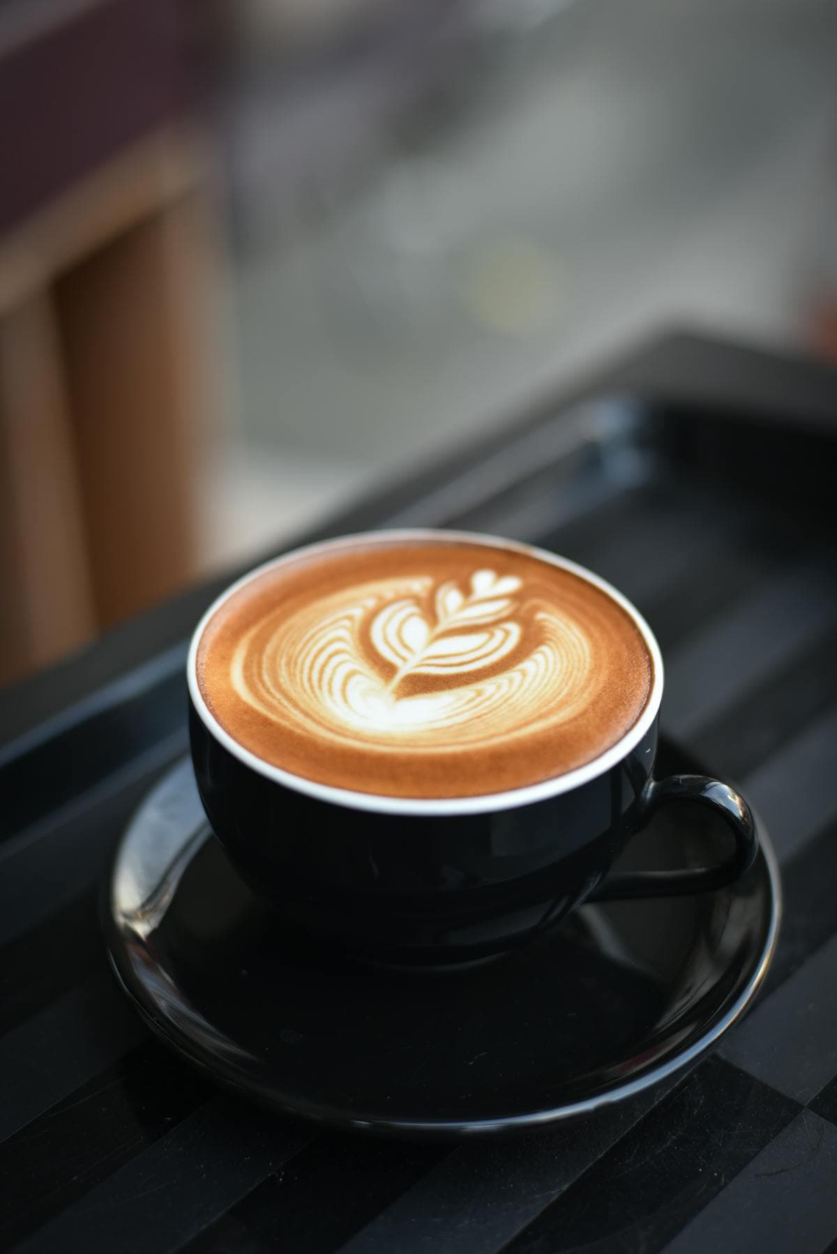 Barista réalisant un latte art rosetta dans une tasse de cappuccino