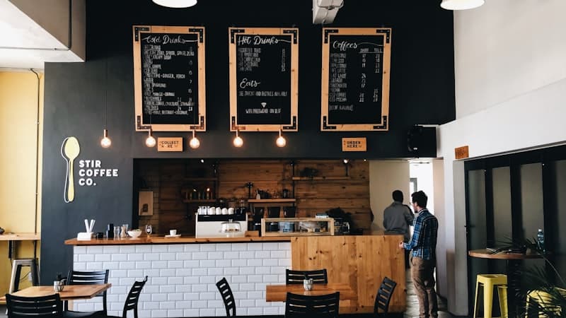 Barista servant un cafe dans un coffee shop chaleureux
